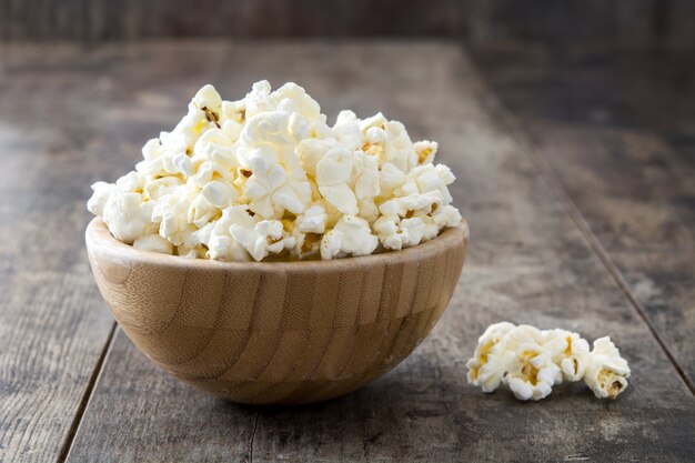 Pop-corn dans un bol sur une table en bois.