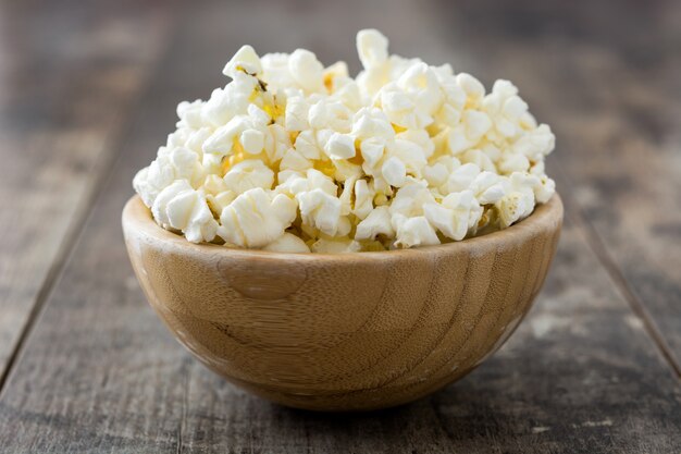 Pop-corn dans un bol sur une table en bois.