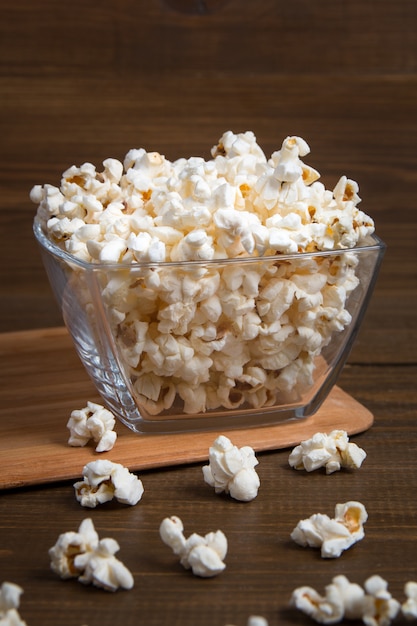 Pop-corn dans un bol en verre sur bois