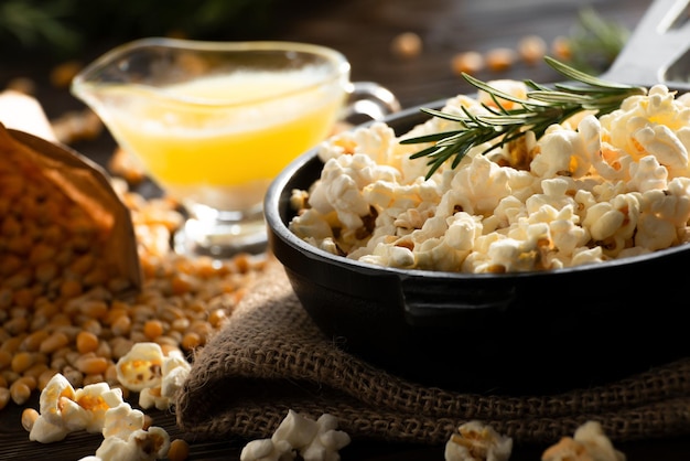 Pop-corn dans une poêle en fonte avec du beurre fondu de côté