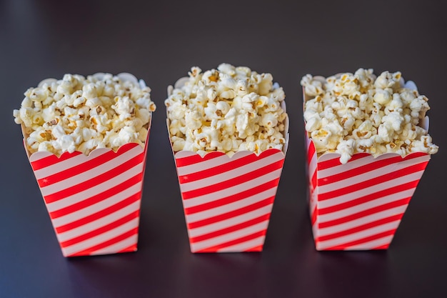 Pop-corn dans un récipient rouge et blanc sur un fond sombre