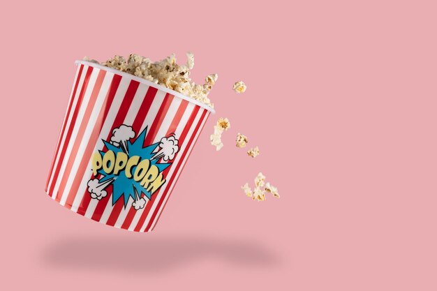 Pop-corn dans un seau rouge et blanc sur fond rose