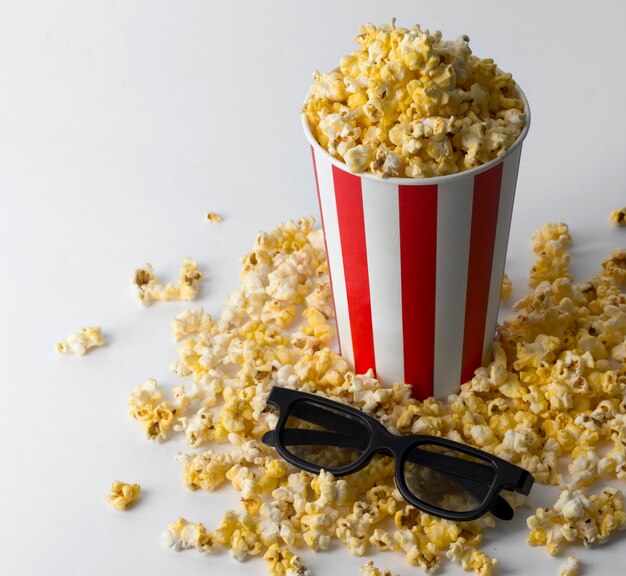 Pop-corn dans un seau rouge rayé avec des lunettes 3d