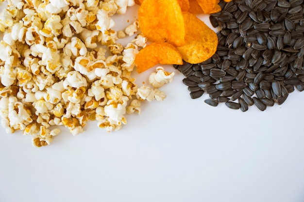 Pop-corn frit et chips sur fond blanc, low angle view