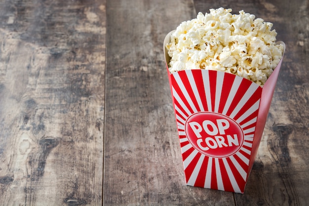 Pop-corn à l'intérieur de l'emballage rayé sur une table en bois