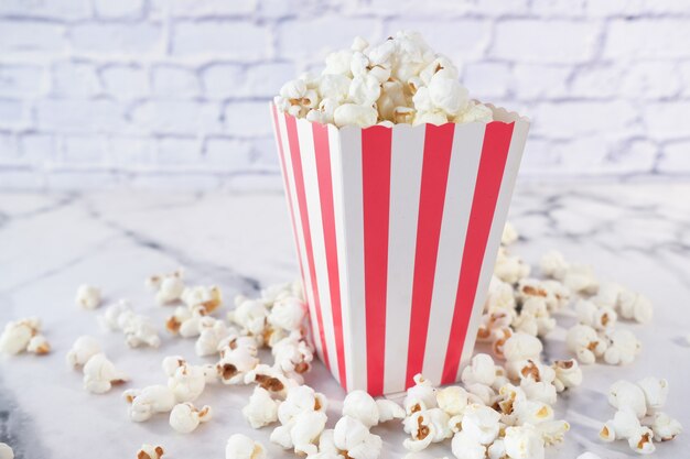 Pop-corn renversé d'un récipient sur blanc