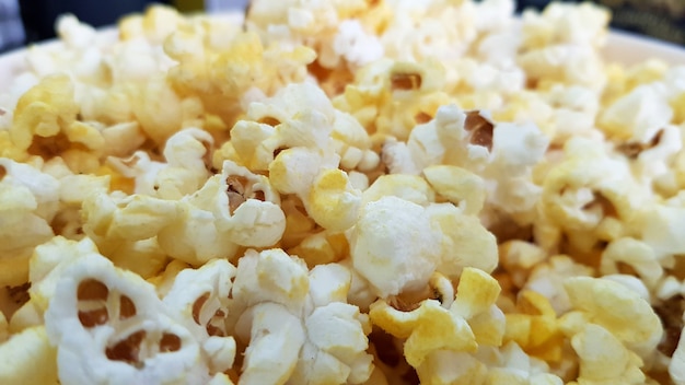 Pop-corn salé épars avec du fromage, fond de texture.