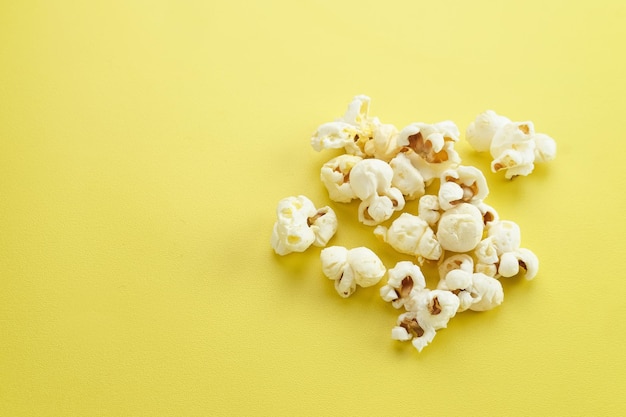 Pop-corn une sorte de collation salée à partir de graines de maïs isolé sur fond jaune mise au point sélectionnée