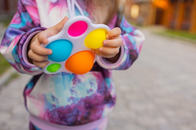 Pop it fidget jouet dans les mains de la fille jouet antistress coloré pour enfants fidget