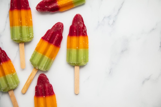 Popcicle de sucette glacée aux fruits d'été sur fond de marbre