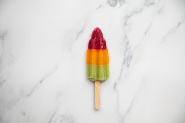 Popcicle de sucette glacée aux fruits d'été sur fond de marbre