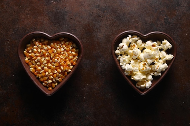 Popcorn dans une assiette en bois marron en forme de coeur sur une table en bois