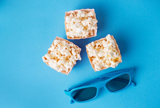 Popcorn avec des lunettes 3d sur fond bleu