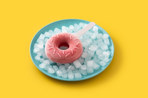 Popsicle beignet aux fraises et glace pilée sur table jaune