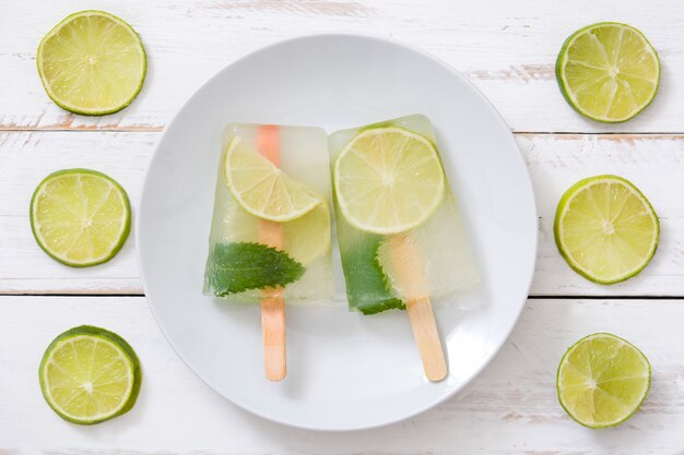 Photo popsicle citron vert sur table en bois blanc