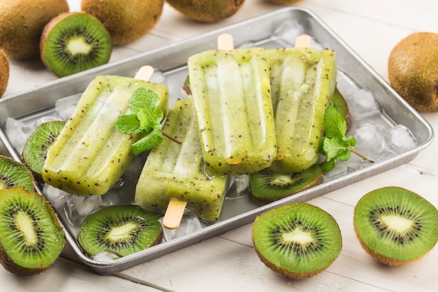 Popsicle de crème glacée au kiwi sur le dessus de la surface de la planche de bois