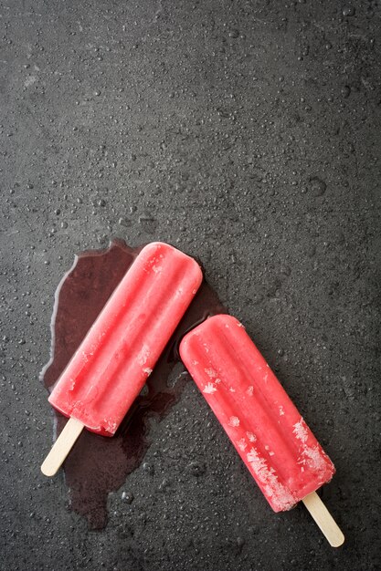 Popsicle fraise sur la vue de dessus de pierre noire