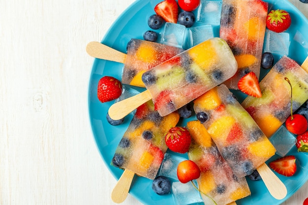 Popsicles faits maison avec des baies et des fruits, vue de dessus.