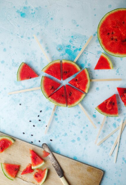 Popsicles de tranche de pastèque bio frais sur fond bleu clair