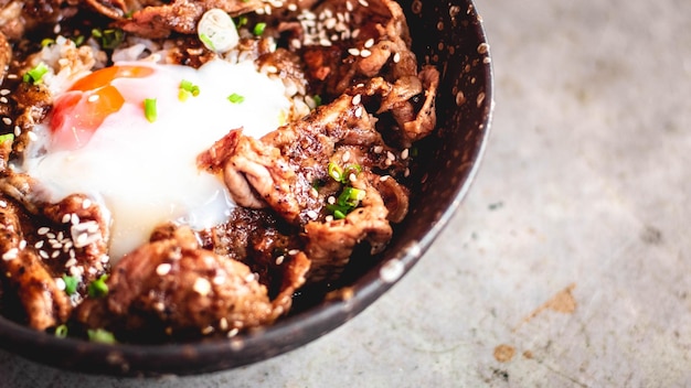 Porc coréen avec œuf sur riz dans un bol en céramique avec une cuillère et une fourchette en métal Un plateau traditionnel coréen repas cuisine alimentaire