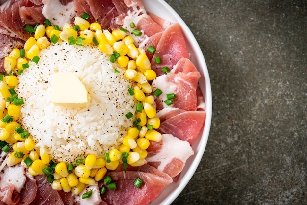 Porc frais cru tranché avec du riz et du maïs sur une assiette et prêt à cuire