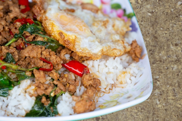 Photo porc frit au basilic et oeuf au plat et riz cuit à la vapeur. nourriture thaïlandaise.