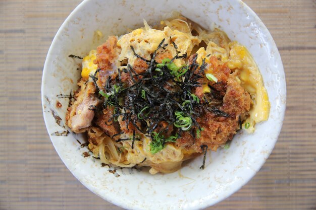 Porc frit japonais avec oeuf sur riz , Katsudon sur fond de bois