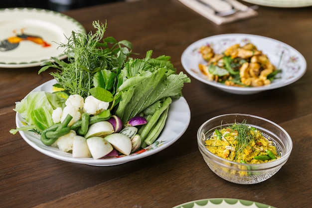 Porc haché épicé frit aux herbes servi avec des légumes. Cuisine thaïlandaise classique.