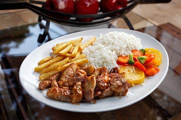 Photo porc haché avec riz, chips de pommes de terre et légumes