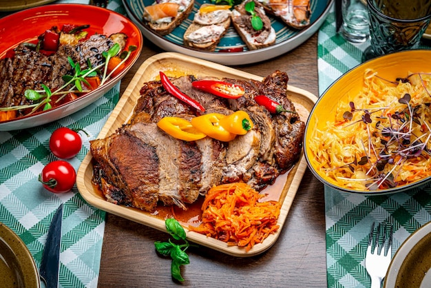 Porc juteux rôti avec des légumes sur une plaque de bois