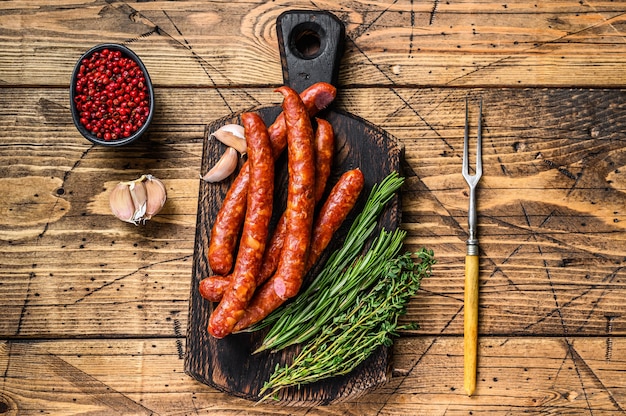 Porc Saucisses fumées avec ajout d'herbes aromatiques fraîches et d'épices. fond en bois. Vue de dessus.