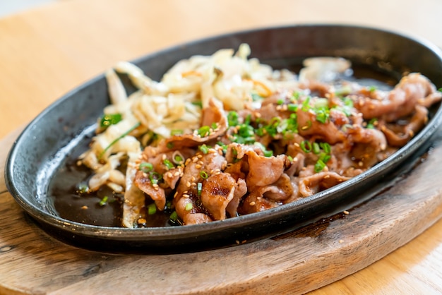 Porc teriyaki dans une poêle chaude avec du chou - style de cuisine japonaise