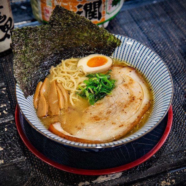 Porc tonkotsu chashu ramen dans le restaurant japonais traditionnel de ramen avec une plaque noire sur un bélier