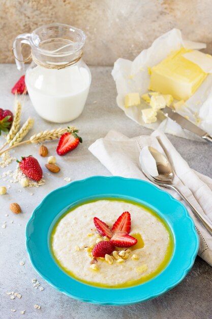 Porridge de flocons d'avoine aux noix et fraises fraîches sur pierre ou ardoise