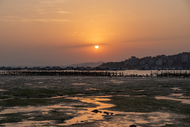 Le port sous le soleil couchant, le soleil rouge et rond