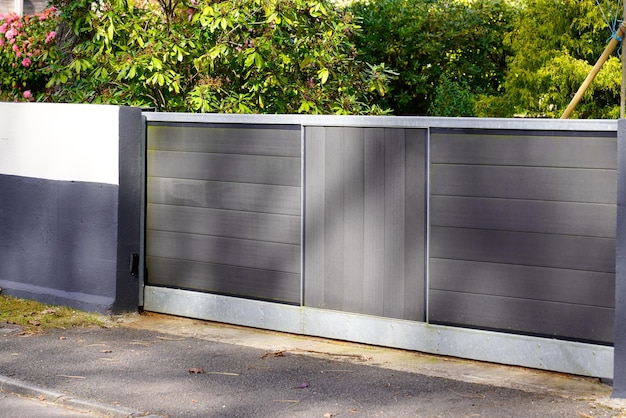 Portail coulissant en aluminium gris et porte en bois porte d'accueil de la maison de banlieue en ville