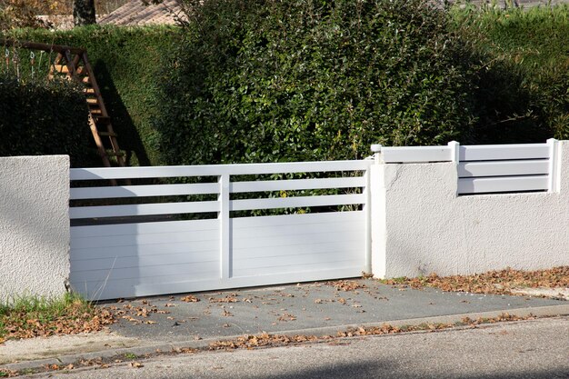 Photo portail moderne en acier blanc bas en aluminium avec lames de conception de maison de banlieue et de clôture