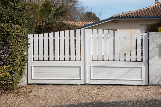 Portail en plastique de porte blanche en pvc haut avec des lames de maison de banlieue