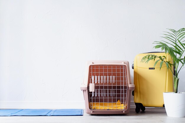 Porte-animaux en plastique ou cage pour animaux de compagnie avec étui de voyage jaune sur le sol à la maison