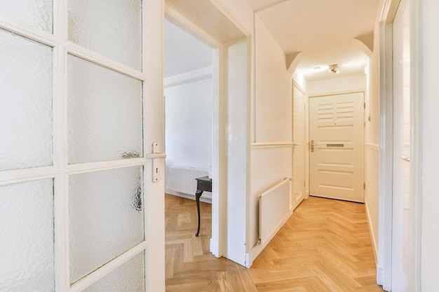 Porte d'appartement moderne avec murs blancs et parquet