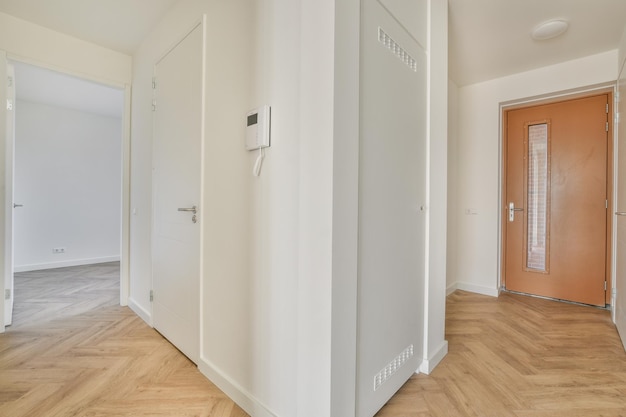 Porte d'appartement moderne avec murs blancs et parquet