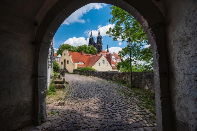 Photo porte en arc de la vieille ville médiévale de meissen avec le magnifique château d'albrechtsburg en arrière-plan dresde saxe allemagne journée ensoleillée au printemps