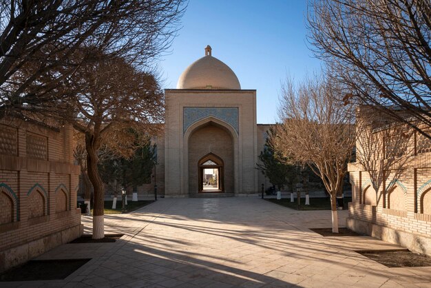 La porte BabiIslam et l'allée du complexe commémoratif Bahauddin Naqshbandi à Boukhara, en Ouzbékistan