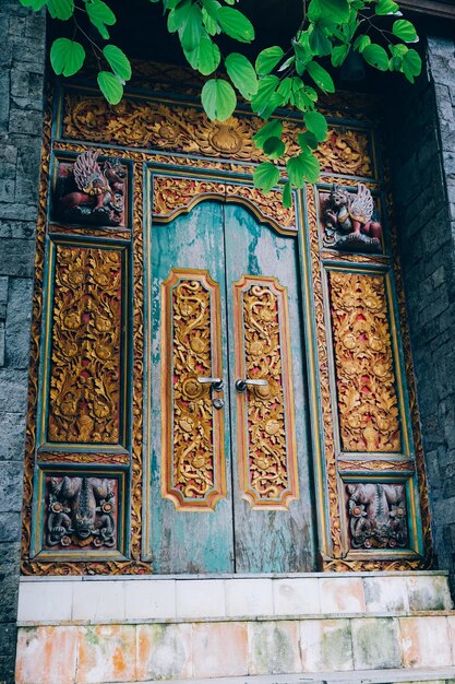 Une porte balinese traditionnelle avec des sculptures et des feuillages intricats