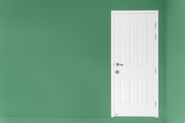 Photo porte blanche fermée sur un mur vert à la maison.