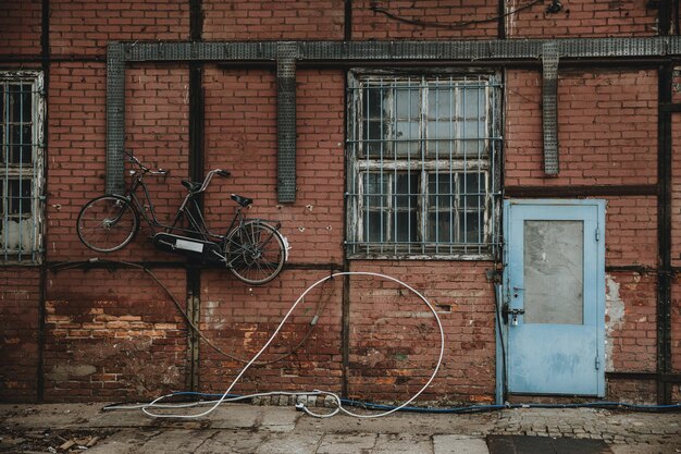 Porte bleue dans un mur de briques rouges d'un bâtiment à colombages avec vélo tandem accroché au mur dans les quais de Gdansk