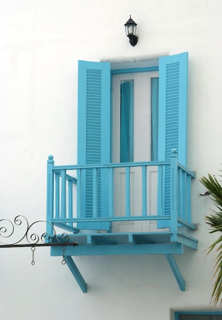 Porte bleue vintage et terrasse sur le mur blanc