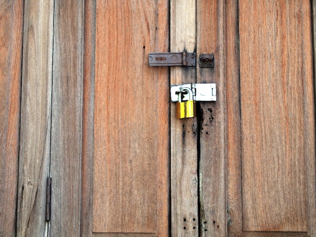 Photo porte en bois de l'ancienne grange avec serrure et chaîne