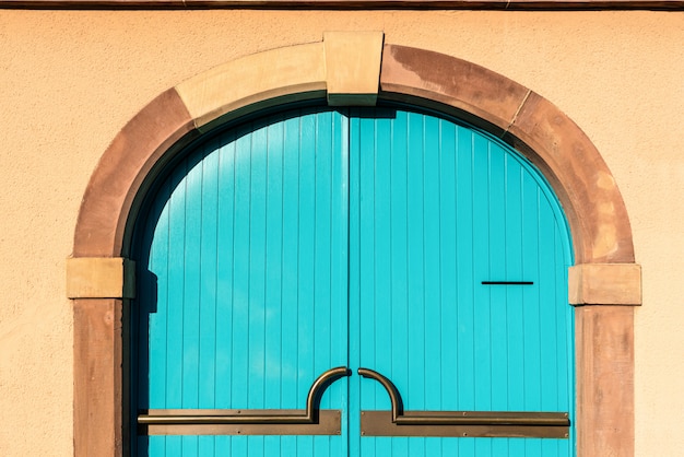 Porte en bois bleue sur mur de briques