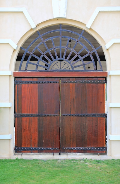 Porte en bois cintrée sur mur de ciment.